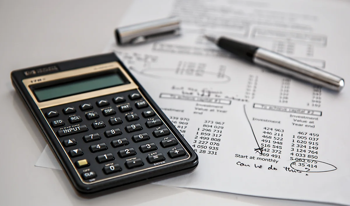 A calculator beside financial paperwork, photographed in 2014.