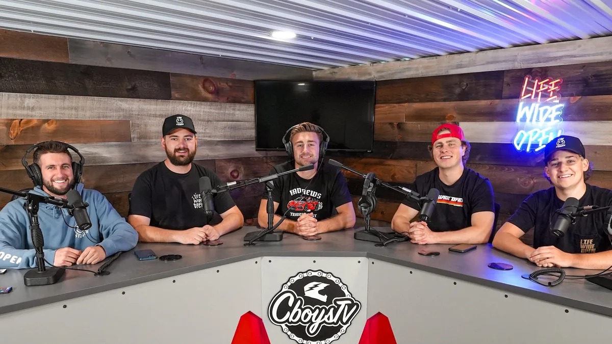 Podcast participants seated around studio microphones.